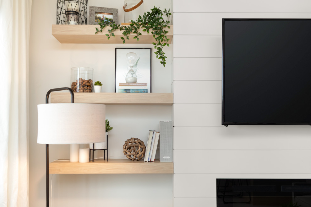Skandinavisk inredning av ett litet allrum med öppen planlösning, med vita väggar, vinylgolv, en hängande öppen spis, en väggmonterad TV och flerfärgat golv