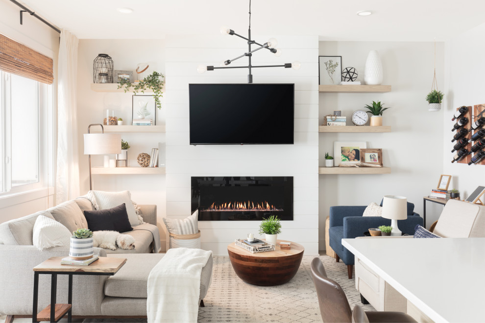 Inspiration for a small scandinavian open plan living room in Vancouver with white walls, vinyl flooring, a hanging fireplace, a timber clad chimney breast, a wall mounted tv and multi-coloured floors.