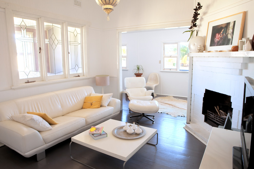 Example of a small trendy painted wood floor living room design in Perth with a corner fireplace, a brick fireplace, white walls and a tv stand
