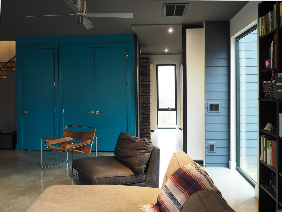 Foto på ett mellanstort funkis allrum med öppen planlösning, med blå väggar, betonggolv, en fristående TV och grått golv