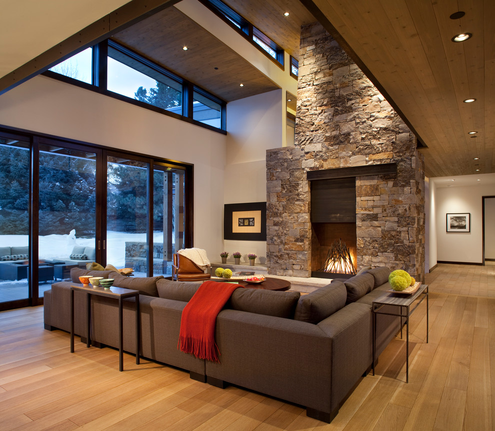 Repräsentatives, Offenes Modernes Wohnzimmer mit weißer Wandfarbe, braunem Holzboden, Kamin und Kaminumrandung aus Stein in Denver