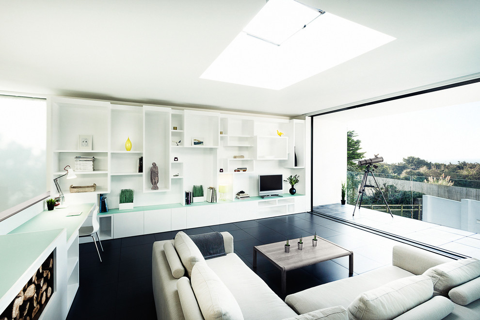 Cette image montre un salon design avec un mur blanc, un téléviseur indépendant et un sol noir.