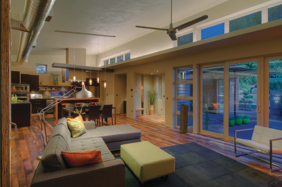 Ispirazione per un piccolo soggiorno design stile loft con pareti multicolore, pavimento in legno massello medio, nessun camino e pavimento marrone