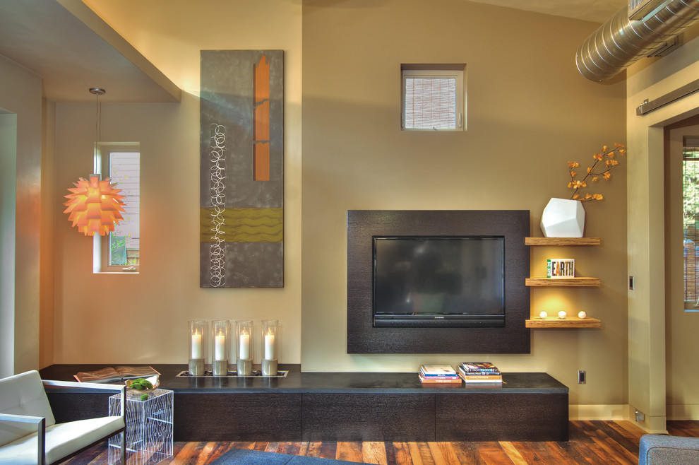 Diseño de salón tipo loft actual pequeño sin chimenea con paredes multicolor, suelo de madera en tonos medios, televisor colgado en la pared y suelo marrón