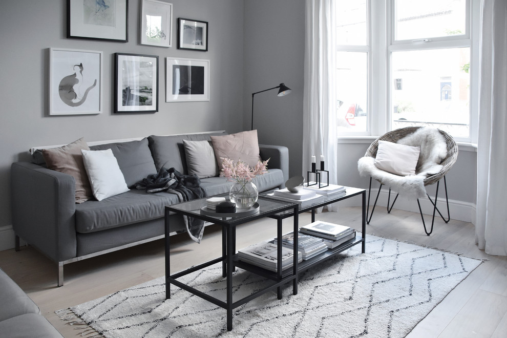 Idée de décoration pour un petit salon nordique fermé avec un mur gris, parquet clair, un sol blanc et éclairage.