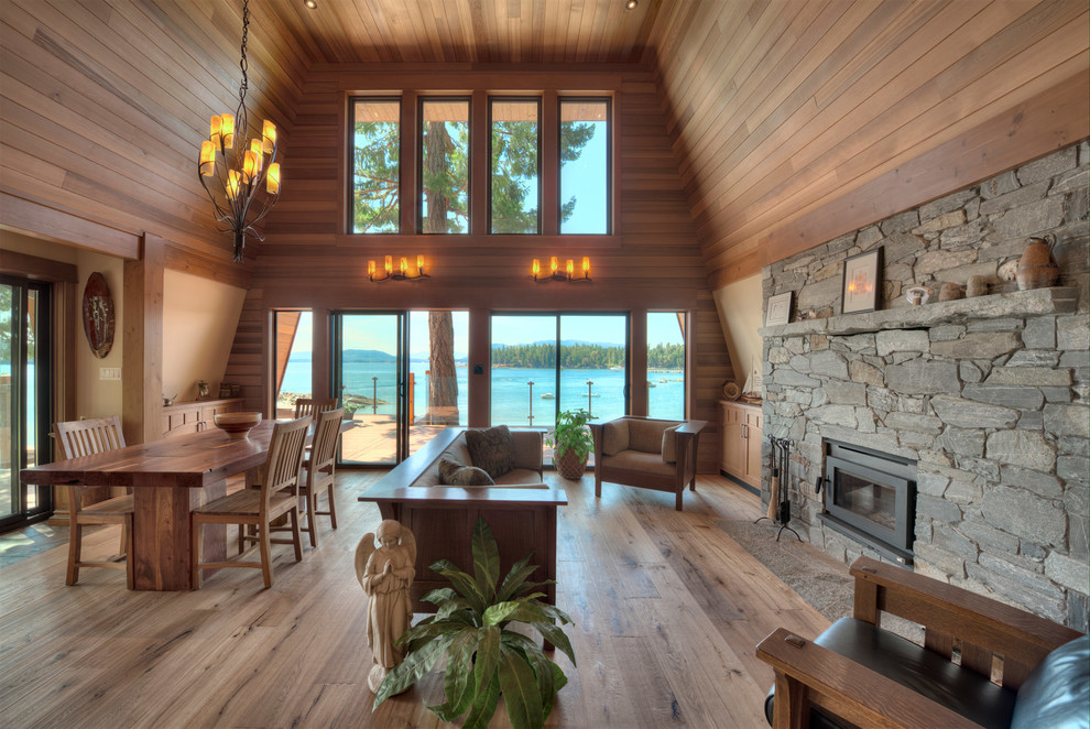 Mittelgroßes, Offenes Uriges Wohnzimmer mit braunem Holzboden, Kaminofen und Kaminumrandung aus Stein in Vancouver