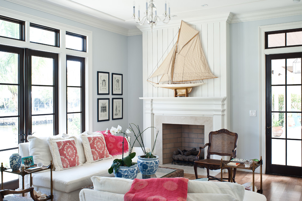 Inspiration for a tropical living room remodel in Miami with blue walls and a standard fireplace