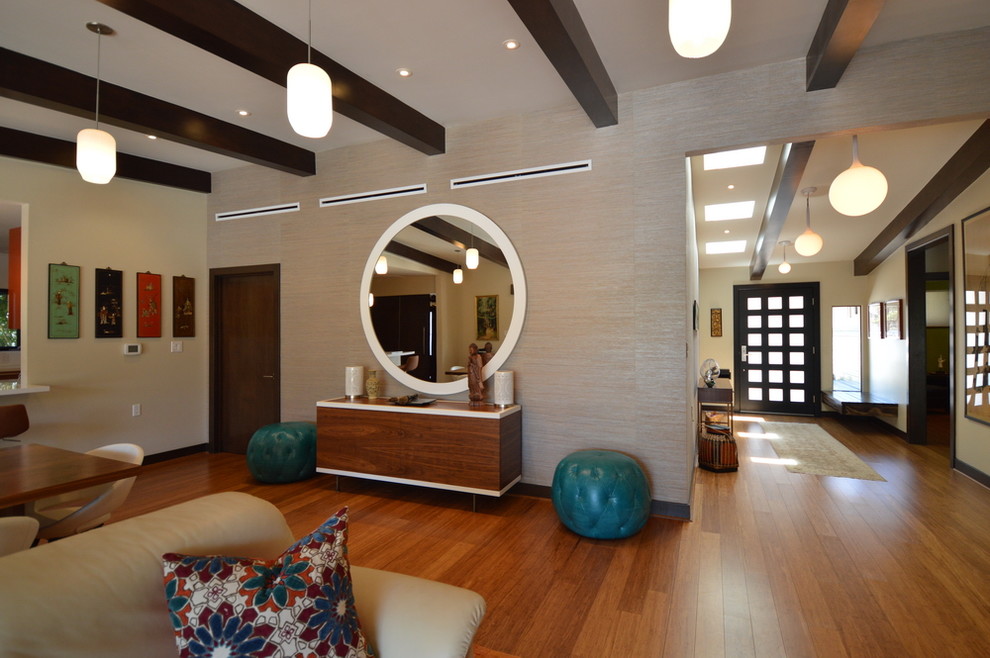 Idee per un grande soggiorno minimalista aperto con pareti multicolore, pavimento in legno massello medio, camino classico e cornice del camino in cemento
