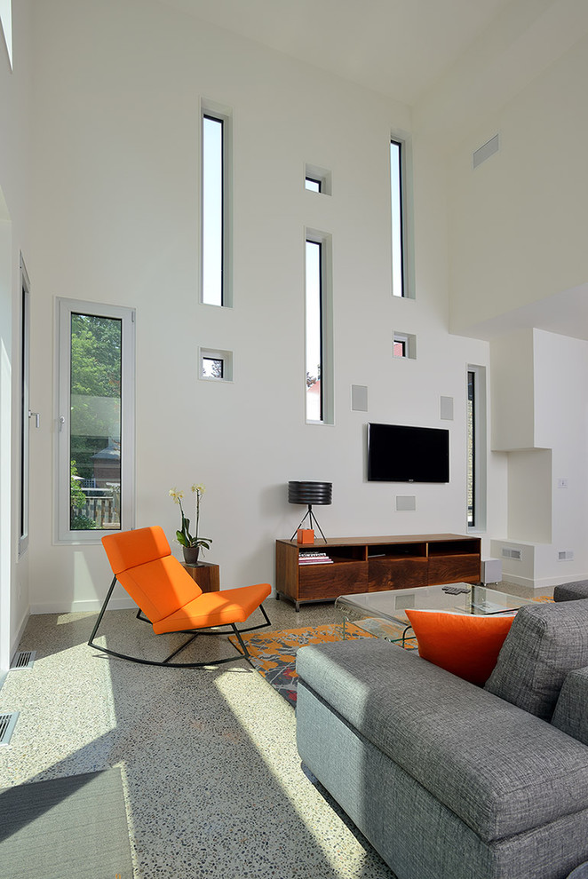 На фото: гостиная комната в современном стиле с белыми стенами и телевизором на стене с