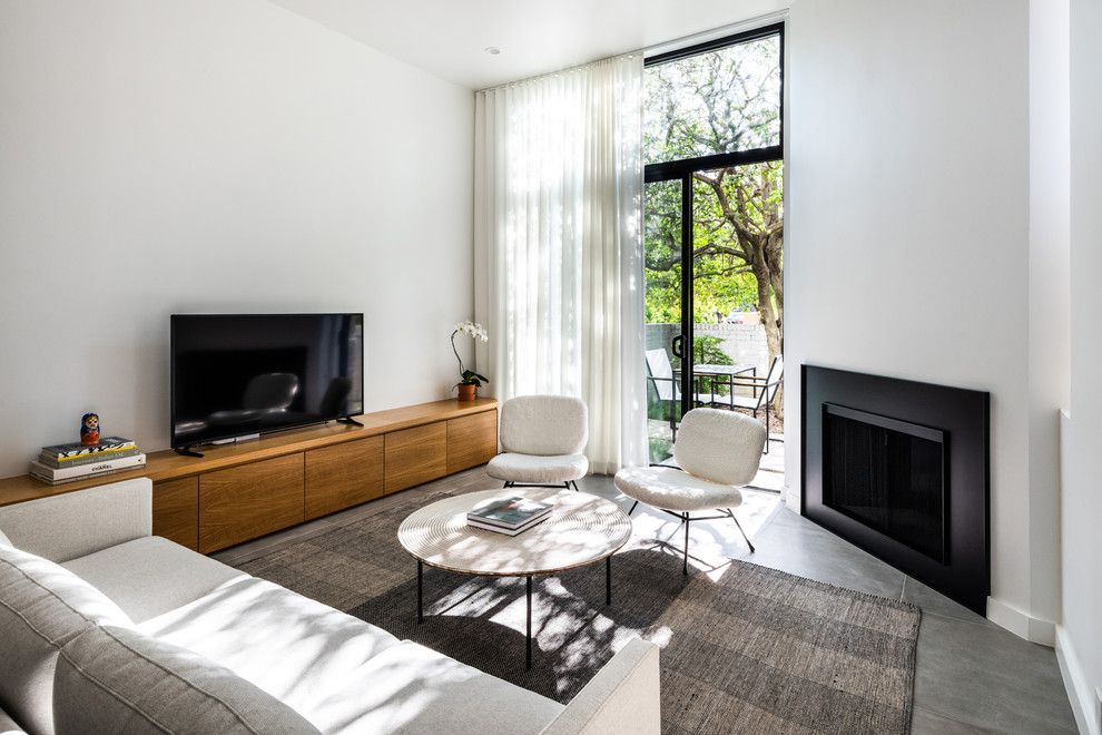 Idee per un soggiorno design con pareti bianche, camino classico, TV autoportante e pavimento grigio