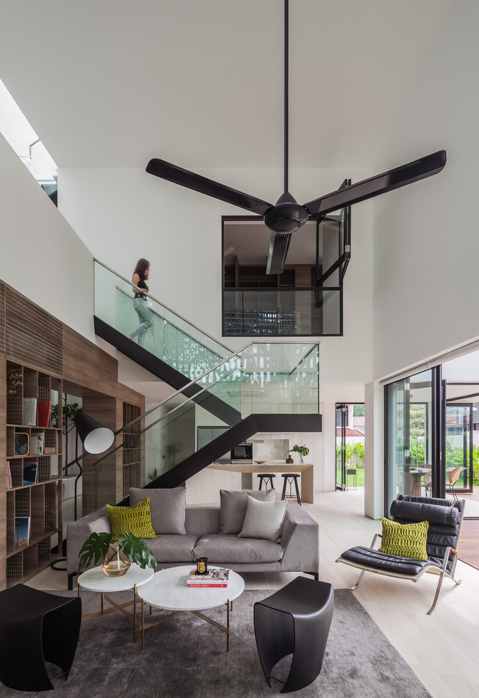 Offenes Modernes Wohnzimmer mit weißer Wandfarbe, hellem Holzboden und beigem Boden in Singapur
