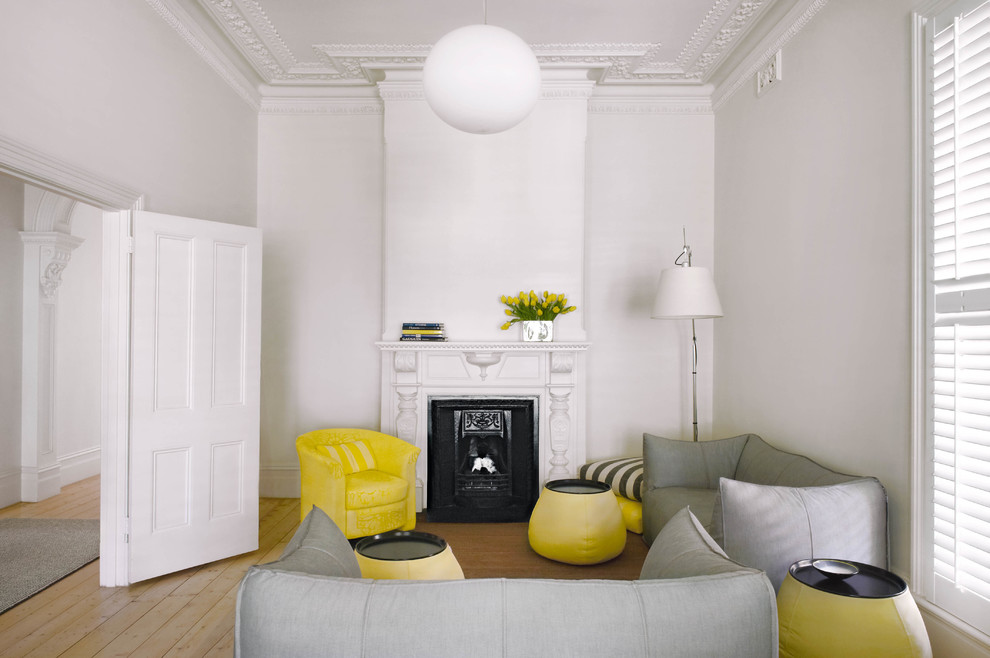 Источник вдохновения для домашнего уюта: изолированная гостиная комната в стиле неоклассика (современная классика) с белыми стенами, светлым паркетным полом и стандартным камином