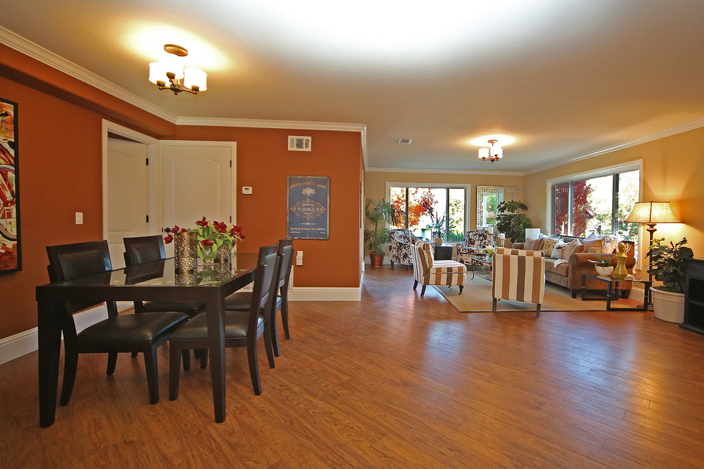 Пример оригинального дизайна: открытая гостиная комната в классическом стиле с оранжевыми стенами и паркетным полом среднего тона
