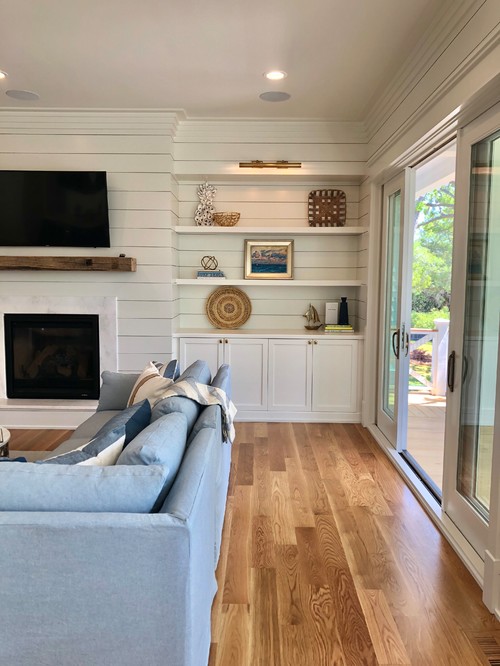 Large farmhouse open concept and formal medium tone wood floor and brown floor living room photo in Charleston with a wall-mounted tv, white walls, a standard fireplace and a plaster fireplace