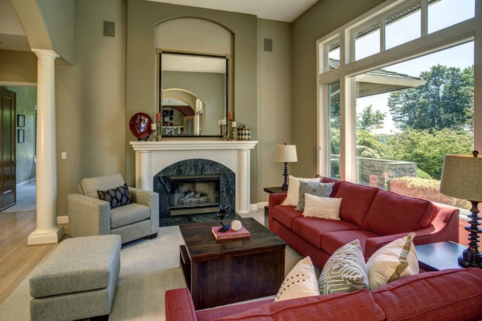 Cette image montre un salon traditionnel avec un mur beige, un sol en bois brun, une cheminée standard et un manteau de cheminée en pierre.