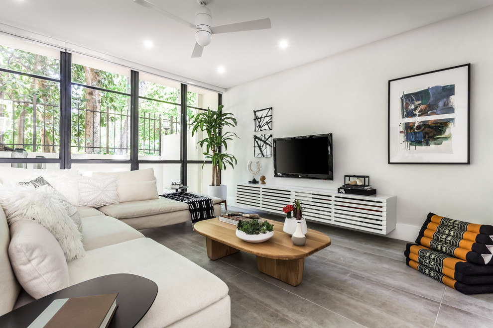 Foto di un soggiorno minimal di medie dimensioni e stile loft con pareti grigie, pavimento in gres porcellanato e pavimento grigio
