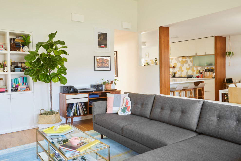 Idee per un soggiorno minimalista aperto con pareti bianche, parquet chiaro e pavimento marrone