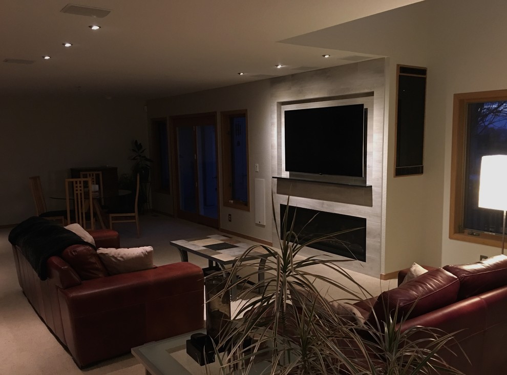 Exempel på ett mellanstort modernt allrum med öppen planlösning, med ett musikrum, grå väggar, heltäckningsmatta, en standard öppen spis, en spiselkrans i trä och en väggmonterad TV