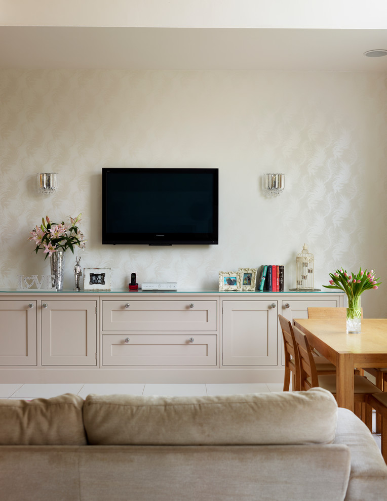 Modelo de salón abierto clásico de tamaño medio sin chimenea con paredes beige y televisor colgado en la pared