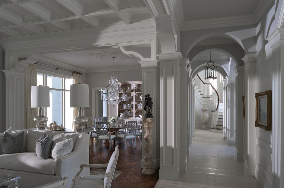 На фото: огромная открытая, парадная гостиная комната в классическом стиле с серыми стенами и темным паркетным полом