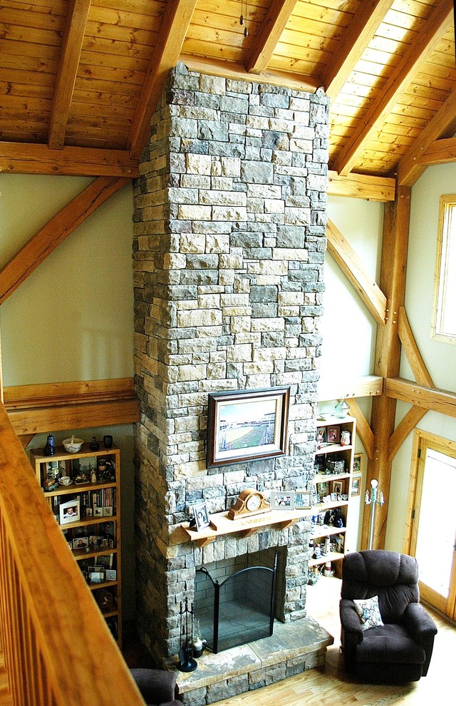 Foto de salón abierto rural de tamaño medio con paredes beige, suelo de madera clara, todas las chimeneas y marco de chimenea de piedra