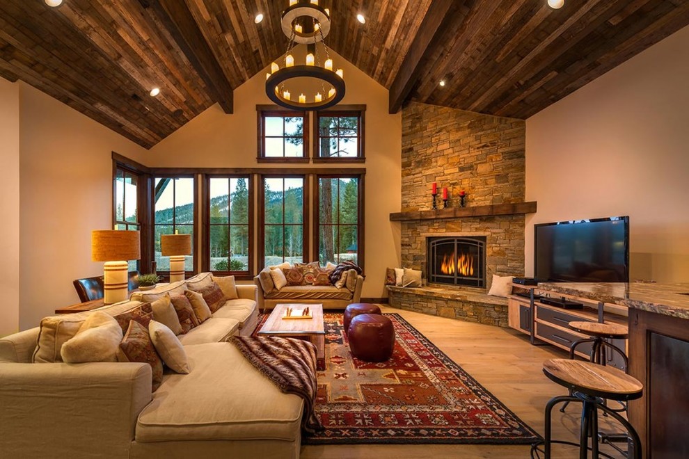 Living room - large rustic enclosed light wood floor living room idea in Seattle with beige walls, a corner fireplace, a stone fireplace and a tv stand