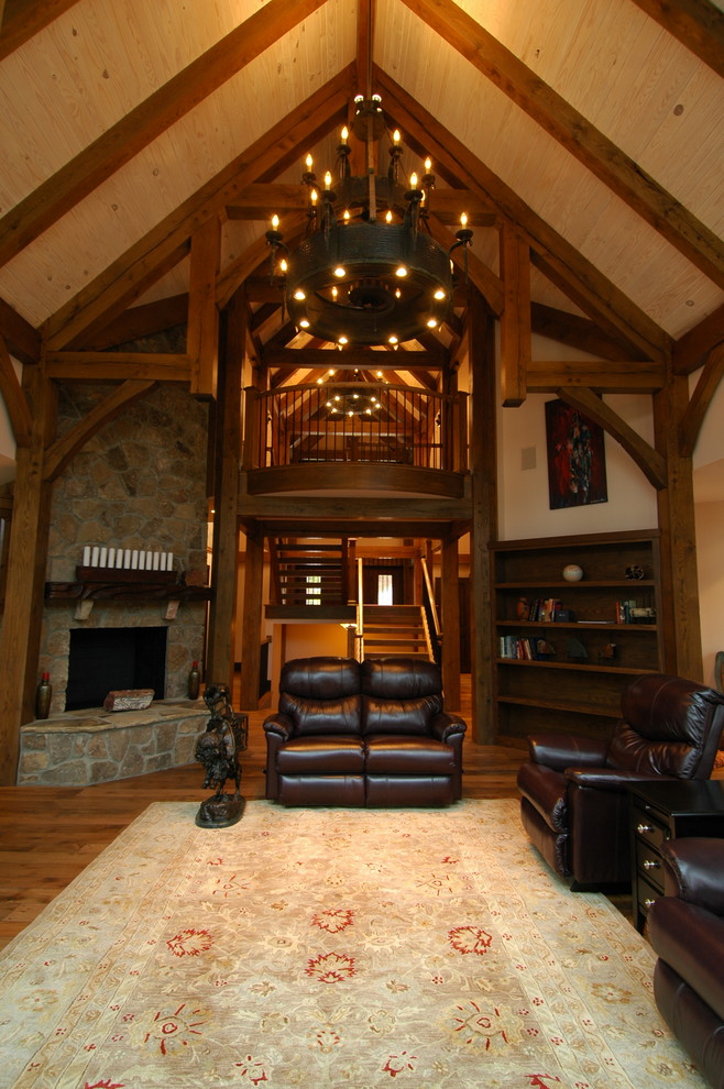 Foto de salón abierto tradicional con suelo de madera oscura, chimenea de esquina y marco de chimenea de piedra