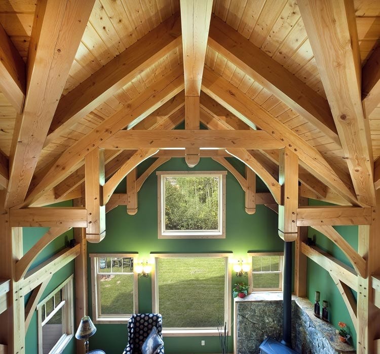 Inspiration pour un salon chalet ouvert avec un mur vert, parquet clair, une cheminée d'angle et un manteau de cheminée en pierre.