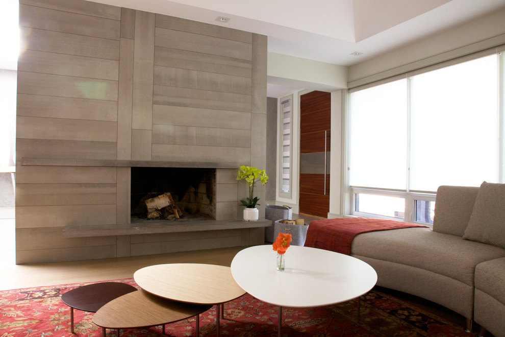 На фото: большая открытая гостиная комната в современном стиле с бежевыми стенами, светлым паркетным полом, стандартным камином, фасадом камина из камня и бежевым полом без телевизора с