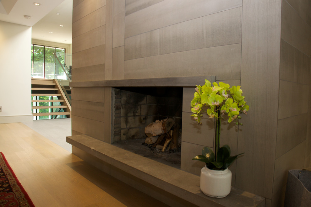Großes, Fernseherloses, Offenes Modernes Wohnzimmer mit beiger Wandfarbe, hellem Holzboden, Kamin, Kaminumrandung aus Stein und beigem Boden in Toronto