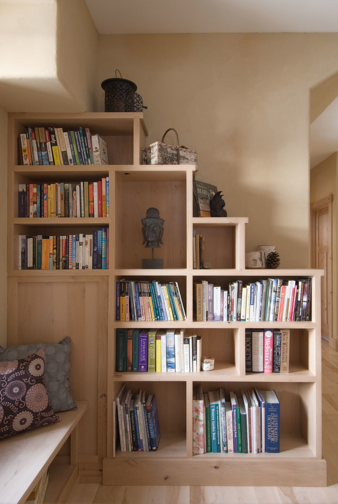 Ejemplo de biblioteca en casa abierta de estilo americano pequeña con paredes beige, suelo de madera clara y suelo beige