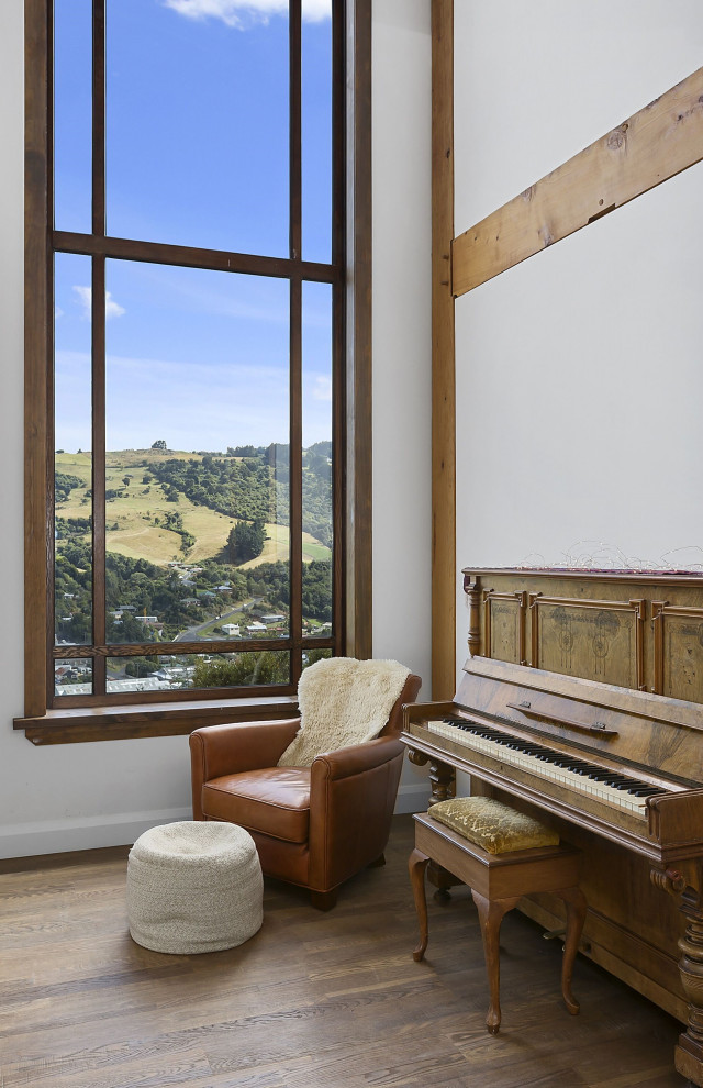 Modelo de salón con rincón musical cerrado vintage con paredes blancas y suelo de madera en tonos medios