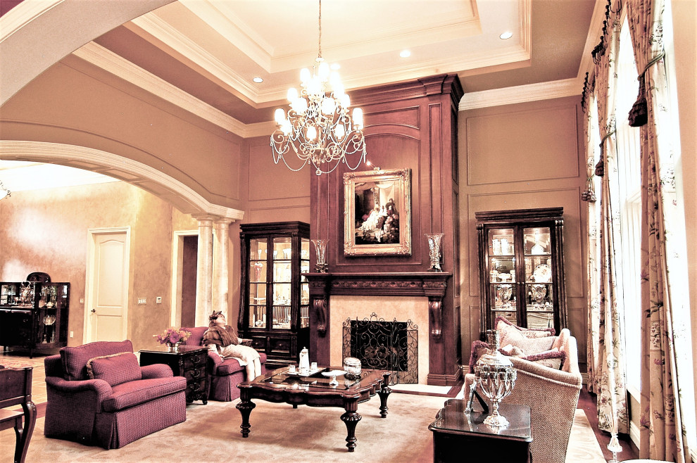 高級な広いトラディショナルスタイルのおしゃれなリビング (ベージュの壁、濃色無垢フローリング、標準型暖炉、テレビなし、木材の暖炉まわり、茶色い床) の写真
