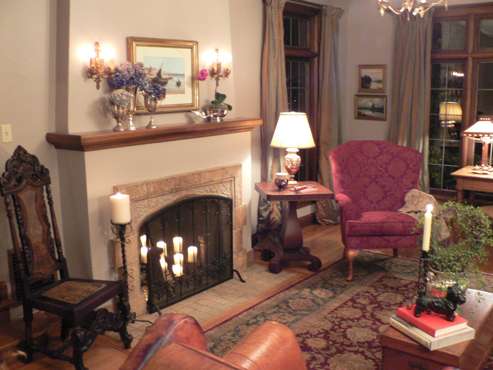 This is an example of a medium sized traditional formal enclosed living room in Seattle with white walls, medium hardwood flooring, a standard fireplace, a stone fireplace surround and no tv.