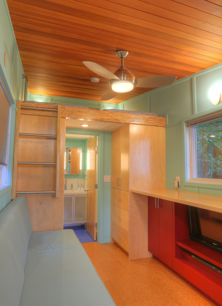 Modelo de salón abierto minimalista pequeño sin chimenea con paredes azules, suelo de corcho y pared multimedia
