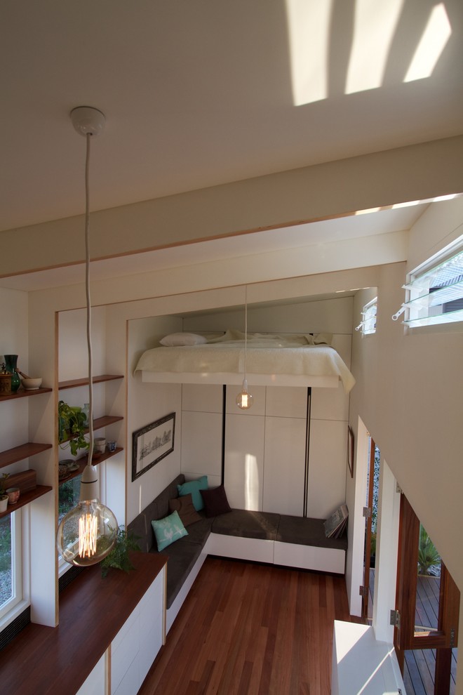 Exempel på ett litet modernt allrum med öppen planlösning, med vita väggar och mellanmörkt trägolv