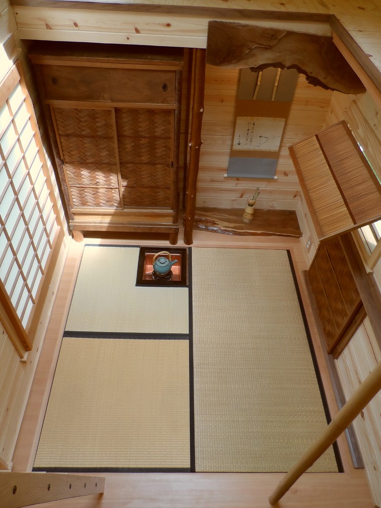 Diseño de salón abierto asiático pequeño sin televisor con paredes marrones y suelo de madera clara