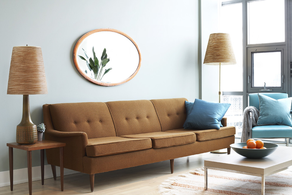 Пример оригинального дизайна: гостиная комната в современном стиле с синими стенами и коричневым диваном
