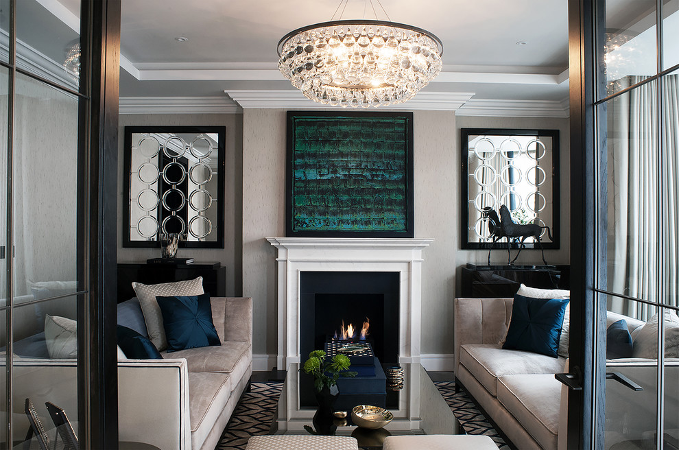 На фото: большая изолированная, парадная гостиная комната в стиле неоклассика (современная классика) с серыми стенами, темным паркетным полом, стандартным камином и фасадом камина из штукатурки без телевизора