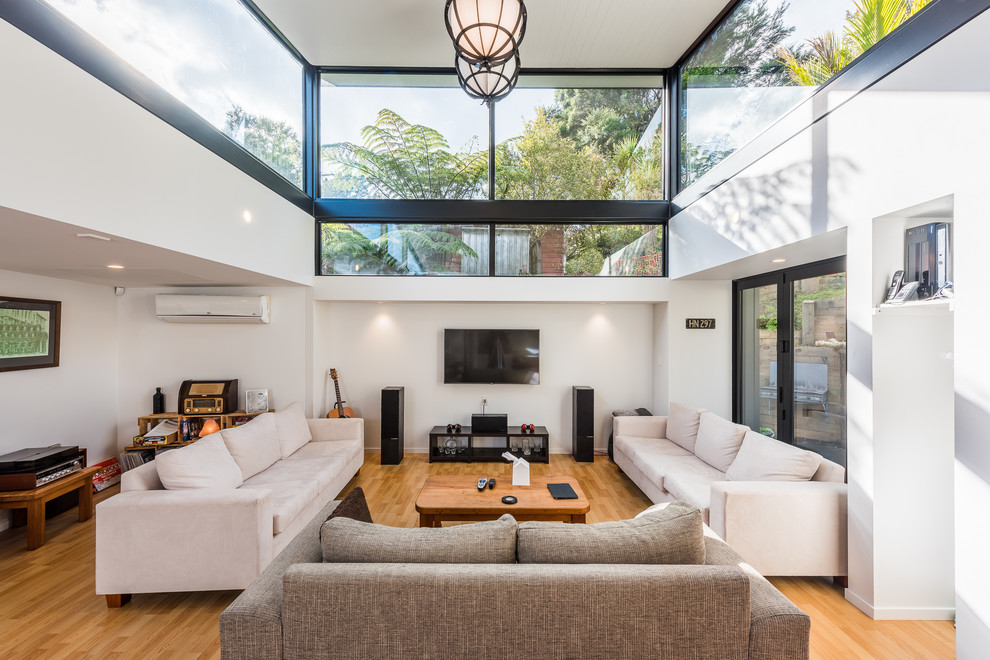 Inspiration för moderna separata vardagsrum, med ett finrum, vita väggar, mellanmörkt trägolv, en väggmonterad TV och orange golv