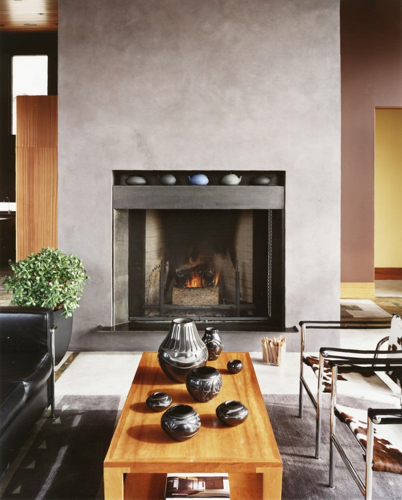 Esempio di un soggiorno minimalista di medie dimensioni e aperto con camino classico e cornice del camino in intonaco