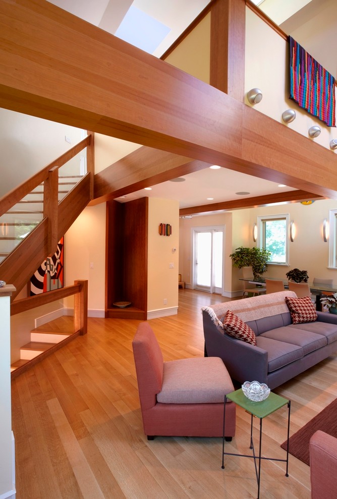 Mittelgroßes, Offenes Modernes Wohnzimmer mit braunem Boden, beiger Wandfarbe, braunem Holzboden, gefliester Kaminumrandung und Gaskamin in Boston