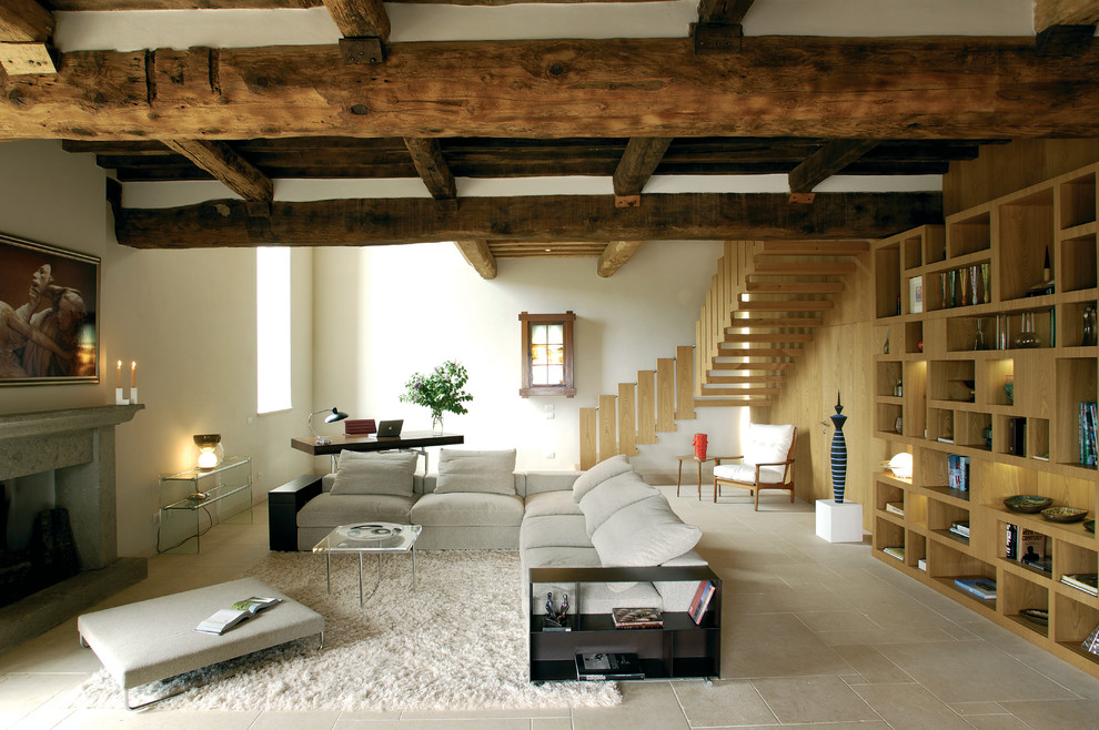 Стильный дизайн: гостиная комната в стиле кантри с белыми стенами, стандартным камином и фасадом камина из камня - последний тренд
