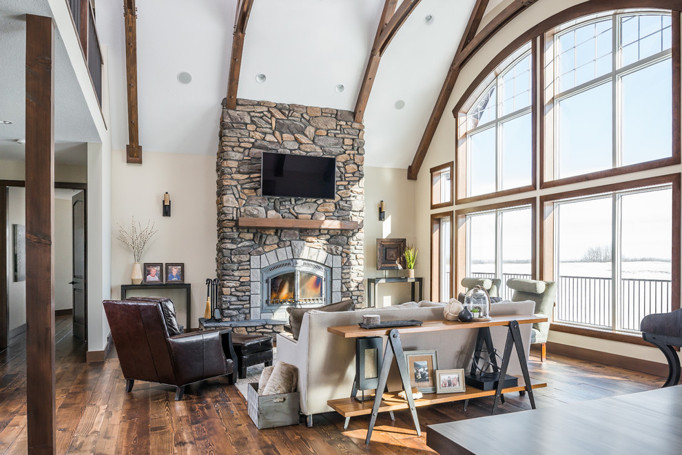 Inspiration for a large contemporary open concept medium tone wood floor living room remodel in Edmonton with beige walls, a standard fireplace, a stone fireplace and a wall-mounted tv