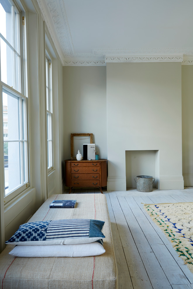 Großes, Repräsentatives, Fernseherloses, Offenes Modernes Wohnzimmer mit beiger Wandfarbe, gebeiztem Holzboden, Kamin und verputzter Kaminumrandung in London