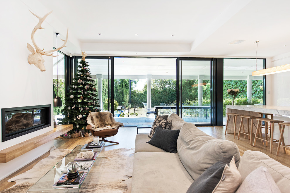 Photo of a contemporary open plan living room in Adelaide with white walls, light hardwood flooring, a metal fireplace surround and a ribbon fireplace.