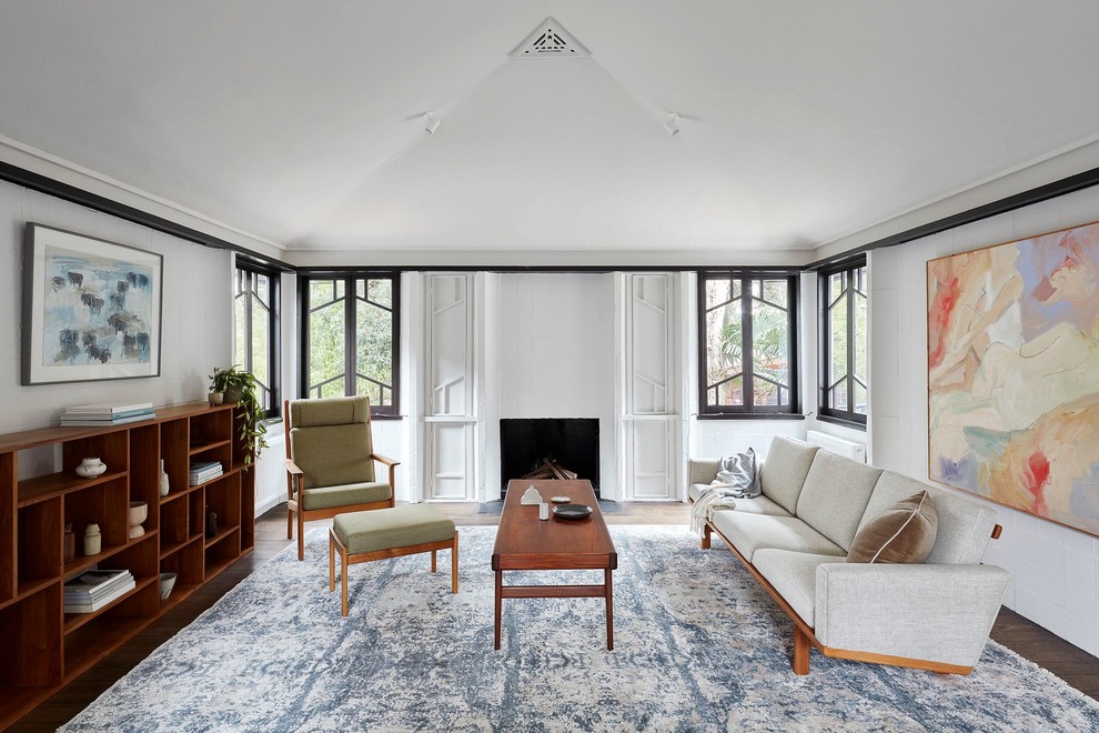 Repräsentatives, Fernseherloses Mid-Century Wohnzimmer mit weißer Wandfarbe, dunklem Holzboden und Kamin in Melbourne