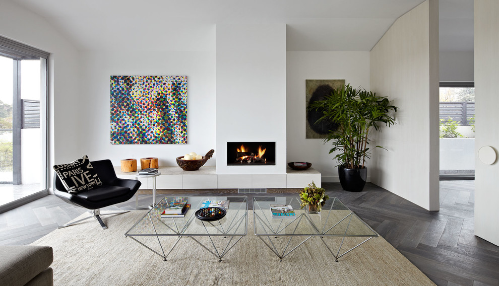 メルボルンにある中くらいなコンテンポラリースタイルのおしゃれなLDK (白い壁、濃色無垢フローリング、標準型暖炉、漆喰の暖炉まわり、グレーの床) の写真