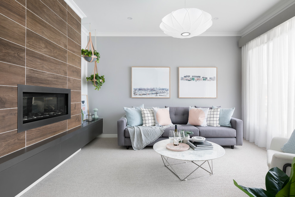 Skandinavisches Wohnzimmer mit grauer Wandfarbe, Teppichboden, Gaskamin und Kaminumrandung aus Stein in Melbourne