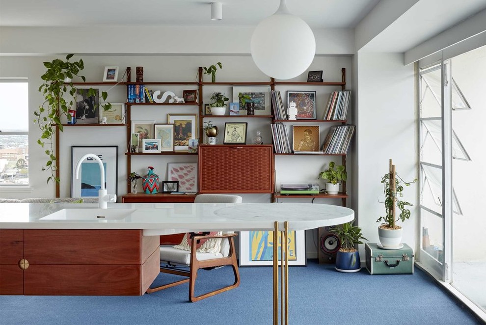 Идея дизайна: маленькая открытая гостиная комната в стиле ретро с ковровым покрытием, синим полом, с книжными шкафами и полками, белыми стенами и скрытым телевизором без камина для на участке и в саду